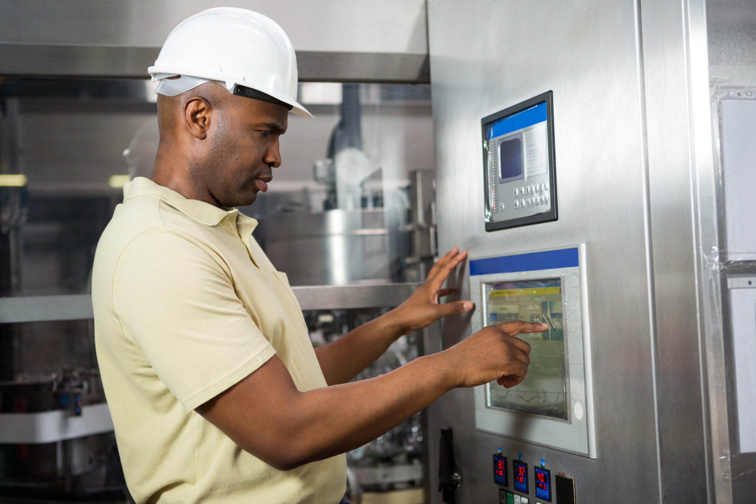 Maintenance technician operating industrial equipment during preventive servicing